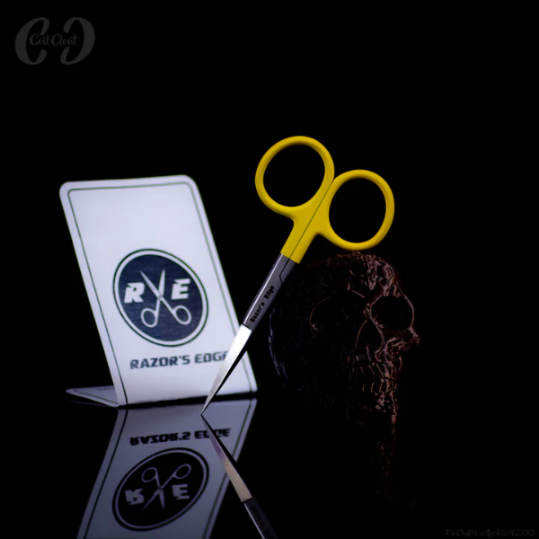 Yellow-handled scissors with a skull and Razor's Edge logo on a black background
