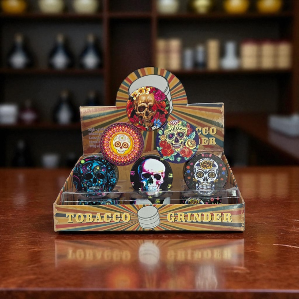 Colorful skull-themed tobacco grinder in a wooden display box on a wooden surface.